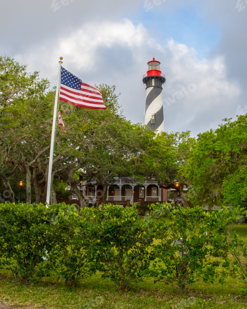 Preview: The St. Augustine, Florida, Lighthouse With The American Flag Waving In The Foreground