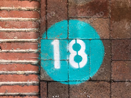 Visualização: Número 18 pintado com spray em uma calçada