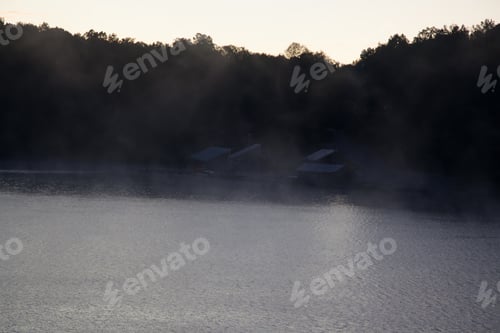 Preview: Early Morning Mist On A Quiet Lake Reflecting Trees With A Sky