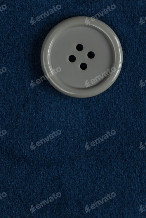 Preview: Clothes Sewing Button On A Blue Fabric Swatch Background