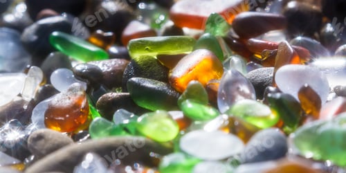 Preview: Close Up Of A Group Of Shiny Pieces Of Sea Glass On The Beach Using A Star Filter To Obtain A