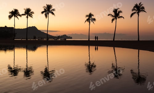 Preview: Sunrise In Waikiki With Diamond Head Reflected In Calm Waters Of Pond As Walkers Walk Along The