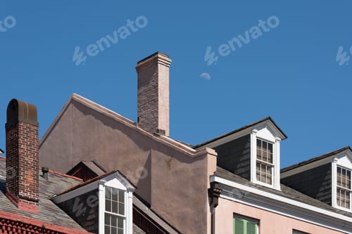 Preview: Early Moon Makes An Appearance Above Chimney And Roofs Of Typical Suburban Town.
