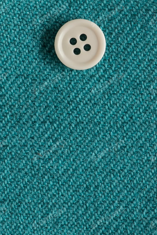 Preview: Clothes Sewing Button On A Turquoise Fabric Swatch Background