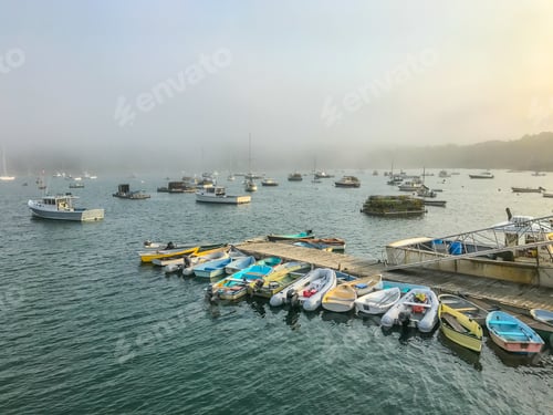 Preview: A Colorful Array Of Boats Anchored In A Harbor In Maine As The Fog Rolls In From The Ocean