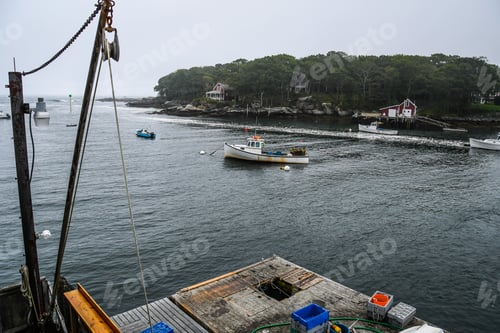 Preview: An Inlet To The Bay With Boats And Homes In The Background An A Lobster Fishing Dock In The