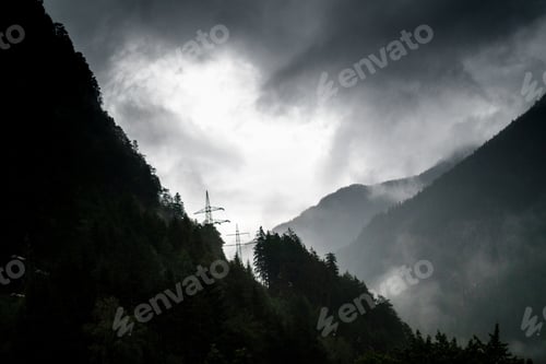 Preview: View Of Electricity Pylons On Top Of Mountains Against Cloudy Sky; Germany