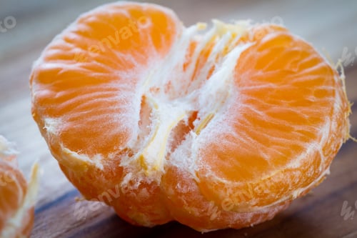 Preview: Close Up Of A Small Orange Or Tangerine On A Wooden Cutting Board