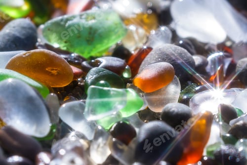 Preview: Close Up Of A Group Of Shiny Pieces Of Sea Glass On The Beach Using A Star Filter To Obtain A