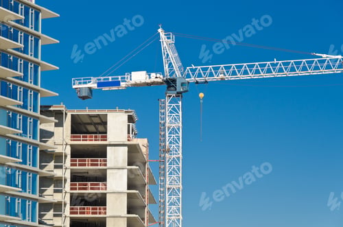 Preview: High-Rise Building Under Construction. The Site With Cranes Against Blue Sky