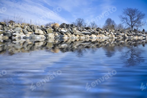 Preview: Frozen Shoreline With Iced Rocks And Blue Sky