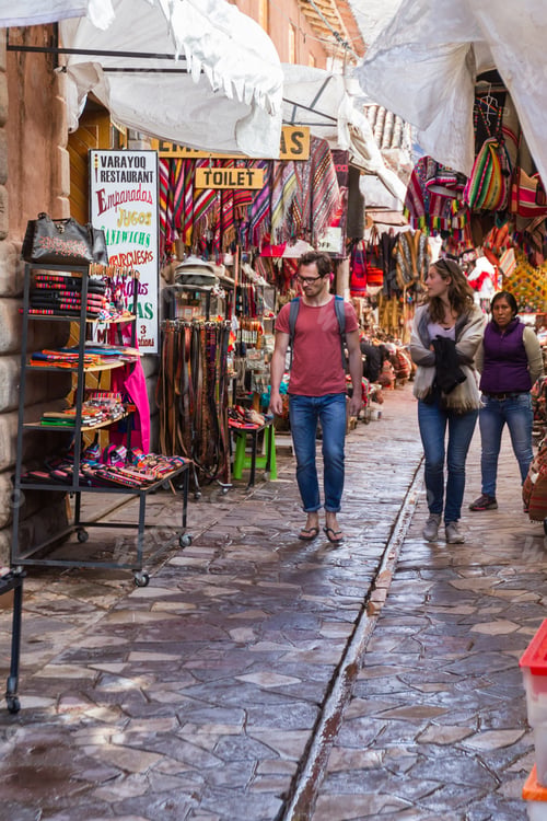 Preview: Pisac, Peru - May 15: Tourists Walking On The Alleyways Of The Market Of Pisac Looking At The