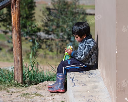 Preview: Chinchero Peru -May 18 : Young Andean Boy With A Large Carton Of Fruit Juice. May 18 2016