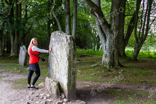 Preview: Tourist Touching A Large Standing Stone In A Well Preserved Bronze Age Cemetery Located Near