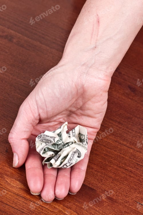 Preview: Hand Holding A Crumbled Dollar Bill Representing The Value Of Money