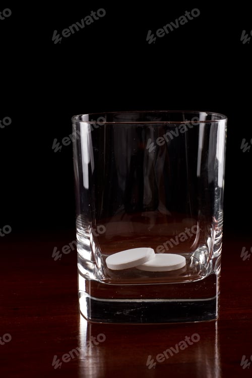 Preview: Pills In A Glass Over A Dark Wooden Table