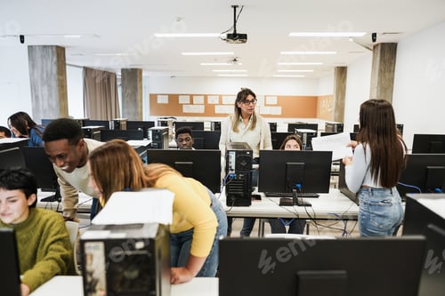 Preview: Mature Teacher Working With Students Inside Computer Room At School - Focus On Woman Face