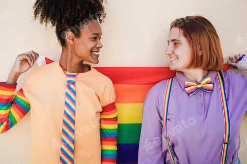 Preview: Happy Women Gay Couple Holding Rainbow Flag Outdoor - Love Concept - Main Focus On African Girl Face