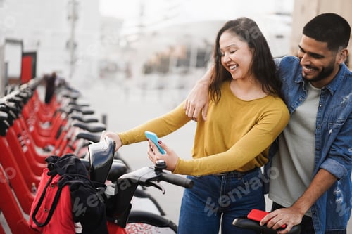 Preview: Young People Renting Electric Bicycle With Smartphone App - Focus On Faces