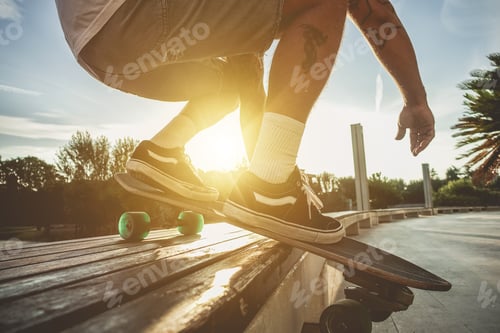 Preview: Silhouette Of Young Man Playing Longboard At Sunset With Back Lighting - Skater Having Fun Doing