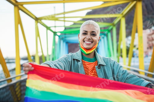 Preview: Portrait Of Gay Woman With Face Mask Holding A Rainbow Flag