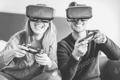 Vista previa: Jóvenes amigos felices jugando a videojuegos con gafas de realidad virtual en su apartamento