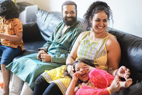 Preview: Happy Indian Family Having Fun At Home Sitting On Sofa - Focus On Mother Face