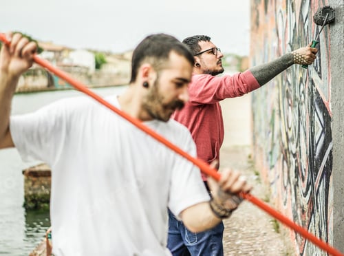 Visualização: Dois escritores cobrindo a parede com sua foto em cinza antes de repintá-la