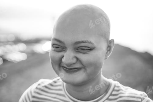 Preview: Happy Bald Girl Smiling In Front Of Camera Outdoor - Soft Focus On Right Eye - Black And White