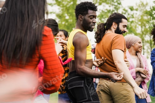Vista previa: Jóvenes diversos que se divierten bailando juntos al aire libre: concéntrese en un hombre gay maquillado
