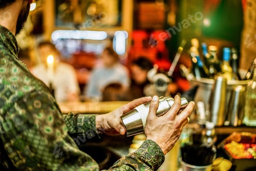 Preview: Trendy Bearded Bartender Shaking And Preparing Cocktails In Night Club Bar - Barman At Work Inside
