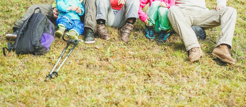 Preview: Legs And Trekking Equipment Of Traveler Family Sitting On A High Mountain - People Having Fun In