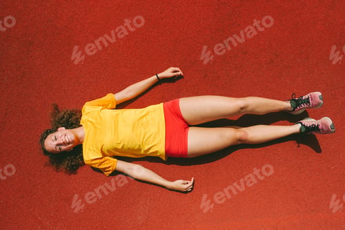 Preview: Top View Of Young Athlete Woman Lying Down After Sport Workout Session - Happy Girl After Running