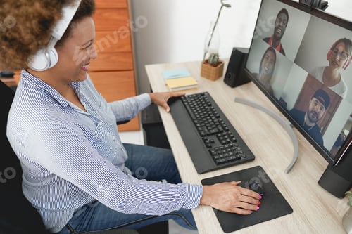 Preview: African Woman Having Video Call With Her Colleagues Using Computer App - Soft Focus On Right Hand