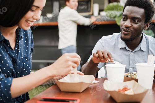 Preview: Multiracial Couple Having Fun Eating At Food Truck Restaurant Outdoor - Focus On African American