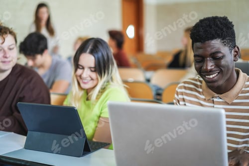 Preview: Young Multiracial Students Working With Tablets Inside Classroom At School University - Focus On