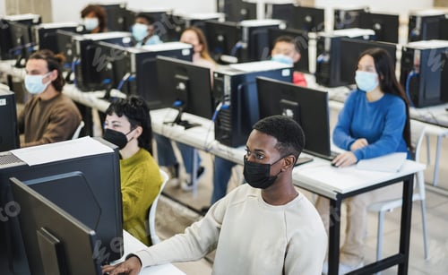 Preview: Young Multiracial Students Using Computers Wearing Protective Mask Inside College Class - Focus