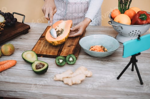 Preview: Young Woman Streaming Online Healthy Food Cooking Lesson With Mobile Phone - Focus On Hands Holding