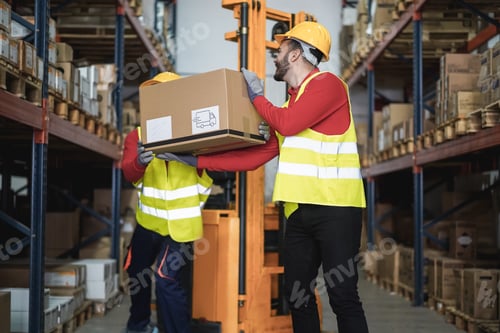 Preview: Industrial Workers Loading Delivery Box Inside Warehouse Store - Focus On Right Man Head