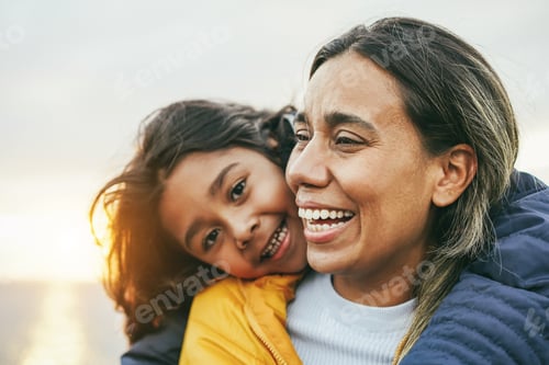 Preview: Happy Latin Mother And Daughter Having Fun During Winter Time - Focus On Mom Face