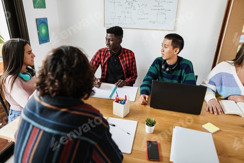 Preview: Multiracial Students Reading Books And Using Laptop Computers While Studying At School - Focus On