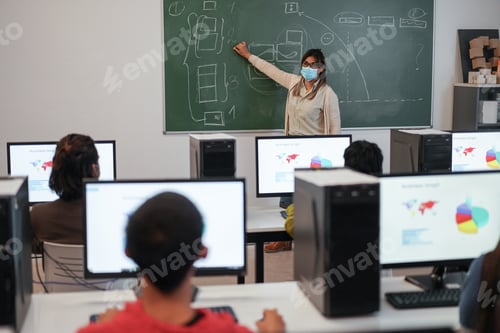 Preview: Multiracial Students Using Computers During Business Class Wearing Safety Masks At School - Focus
