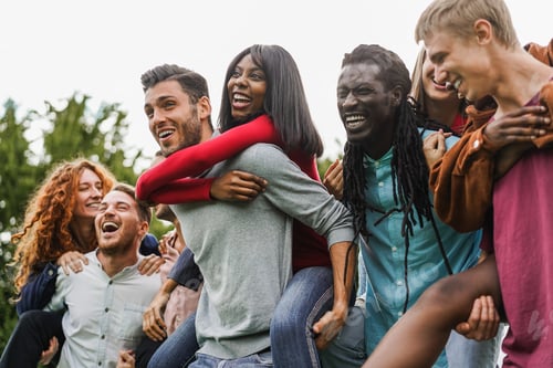 Preview: Cheerful Adults Laughing Together Outdoors on Piggybacks