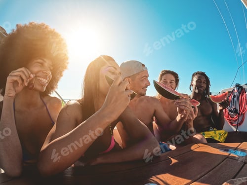 Preview: Happy Multiracial Friends Eating Watermelon While Doing Sea Tour With Sailing Boat - Soft Focus On