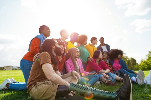 Preview: Multiethnic Diverse People Having Fun Outdoor Sitting On Grass At City Park - Main Focus On
