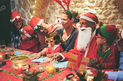 Preview: Happy Family Having Fun At Dinner During Christmas Time - Soft Focus On Grandfather Face