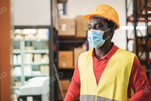 Preview: African Warehouse Man Working While Wearing Safety Mask - Focus On Face