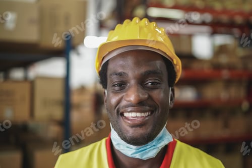 Preview: African Worker Man Smiling On Camera Inside Warehouse During Coronavirus Outbreak - Focus On Mouth
