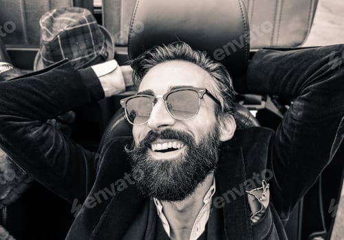 Preview: Fashion Portrait Of Young Bearded Man Ready For Road Trip - Cheerful Hipster Guy Sitting In Car