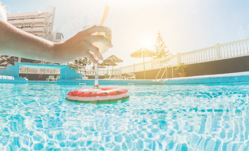 Preview: Young Woman Drinking Tropical Cocktail Inside Resort Swimming Pool - Female Hand Taking Her Drink